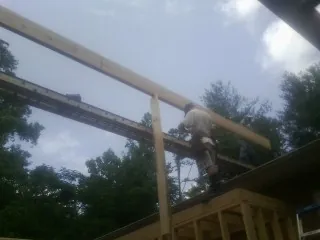 Carpenter setting a ridge beam over a new addition frame — Ice Dam Removal by Roofing Brothers in Carpenter